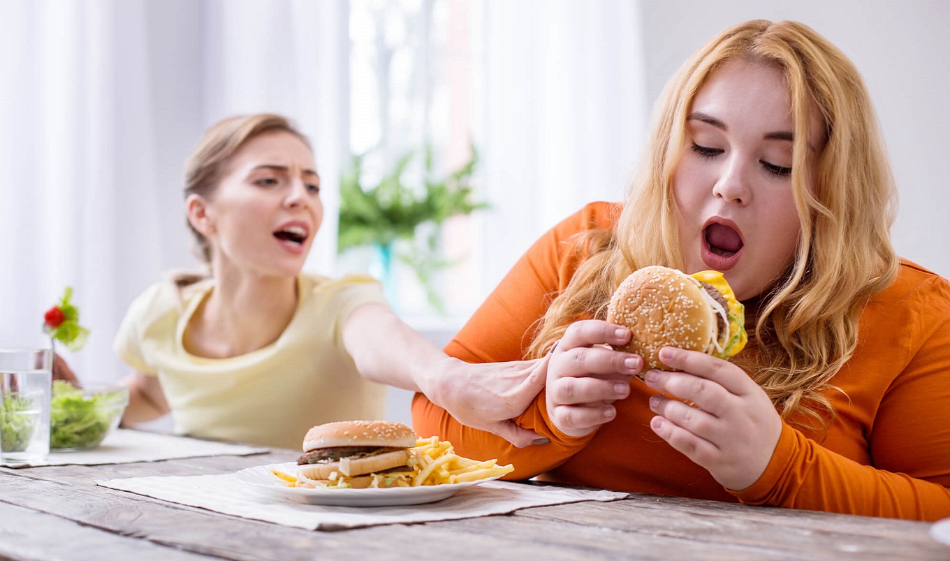gruba kobieta je hamburgera z frytkami